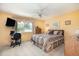 Comfortable bedroom with a ceiling fan and window, adjacent to a workspace and dresser at 22375 Edgewater Dr # 149, Punta Gorda, FL 33980