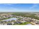 Wide aerial shot of a suburban neighborhood with a lake and lush green spaces under a clear blue sky at 2486 Buckthorn Loop, North Port, FL 34289