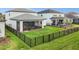 Spacious backyard features a screened-in patio, lush lawn, and secure black metal fencing for privacy at 2486 Buckthorn Loop, North Port, FL 34289