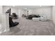 Relax in this spacious bonus room with gray carpeting, neutral paint and a ceiling fan at 2486 Buckthorn Loop, North Port, FL 34289