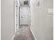 Walk the carpeted hallway with white paint and white doors leading to different rooms at 2486 Buckthorn Loop, North Port, FL 34289