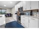 Well-lit kitchen boasts stainless steel appliances, white cabinetry, and countertop space, ideal for everyday cooking at 2486 Buckthorn Loop, North Port, FL 34289