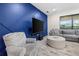 Beautiful living room featuring an accent wall, large screen television, and comfortable seating area at 2486 Buckthorn Loop, North Port, FL 34289