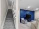 This living room features a custom blue accent wall and carpeted stairs at 2486 Buckthorn Loop, North Port, FL 34289