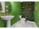 Unique powder room with green walls, creative plant decor, and a pedestal sink at 2486 Buckthorn Loop, North Port, FL 34289