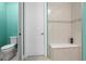 The toilet and shower in the bathroom feature white tile and a tiled bench at 2486 Buckthorn Loop, North Port, FL 34289