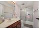 Bathroom with wood vanity, neutral-toned wallpaper and walk-in shower at 25188 Marion Ave # D303, Punta Gorda, FL 33950