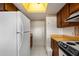 Cozy kitchen featuring wooden cabinetry, white appliances, and ample counter space at 25188 Marion Ave # D303, Punta Gorda, FL 33950