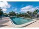 Community pool surrounded by a brick patio and lush greenery, perfect for relaxation at 25188 Marion Ave # D303, Punta Gorda, FL 33950