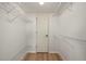 Walk-in closet with built-in metal shelving and wood flooring at 25188 Marion Ave # D303, Punta Gorda, FL 33950