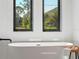 Bright bathroom features a soaking tub beneath two windows offering outdoor views at 260 Long Meadow Ln, Rotonda West, FL 33947