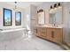 Modern bathroom with a soaking tub, walk-in shower, dual sinks, and designer tile at 260 Long Meadow Ln, Rotonda West, FL 33947