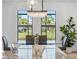 Dining room features an elegant light fixture and views of the landscaped yard at 260 Long Meadow Ln, Rotonda West, FL 33947