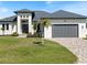 Charming home showcasing its manicured lawn, brick driveway, and inviting garage at 260 Long Meadow Ln, Rotonda West, FL 33947