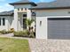Attractive home exterior with well-maintained landscaping, brick paver driveway, and garage at 260 Long Meadow Ln, Rotonda West, FL 33947