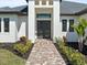 Inviting front entrance with modern double doors, sidelights, and a brick-paved walkway at 260 Long Meadow Ln, Rotonda West, FL 33947