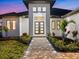 Welcoming home entrance featuring stylish double doors, sidelights, and professionally landscaped walkway at 260 Long Meadow Ln, Rotonda West, FL 33947