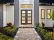 Close-up of the elegant front entrance with double doors, sidelights, and brick-paved walkway at 260 Long Meadow Ln, Rotonda West, FL 33947