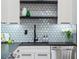 Kitchen with mosaic tile backsplash, black hardware, stainless steel appliances, and open shelving at 260 Long Meadow Ln, Rotonda West, FL 33947