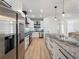 Open-concept kitchen features stainless steel appliances, an island, and white cabinetry at 260 Long Meadow Ln, Rotonda West, FL 33947