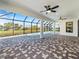 Spacious screened patio with stylish brick flooring, offering a covered outdoor space with a view of the pool and backyard at 260 Long Meadow Ln, Rotonda West, FL 33947