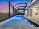 Relaxing in-ground pool inside a screened enclosure, featuring cool blue water, brick pavers, and an evening sky at 260 Long Meadow Ln, Rotonda West, FL 33947