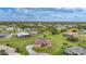 Wide aerial view of a peaceful neighborhood featuring lush greenery and spacious lawns around well-maintained homes at 26389 Villa Maria Dr, Punta Gorda, FL 33983