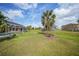 Spacious backyard with lush green grass, mature trees, and a screened-in lanai, perfect for outdoor enjoyment at 26389 Villa Maria Dr, Punta Gorda, FL 33983