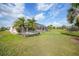Expansive backyard featuring a screened-in lanai, offering a serene outdoor living space with lush greenery at 26389 Villa Maria Dr, Punta Gorda, FL 33983