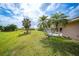 Lush backyard with a screened-in pool area and palm trees, offering a private and tropical outdoor retreat at 26389 Villa Maria Dr, Punta Gorda, FL 33983