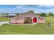 Charming single-story home with well-manicured lawn and bright red front door at 26389 Villa Maria Dr, Punta Gorda, FL 33983
