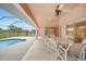 Charming outdoor patio area with a ceiling fan, ideal for dining and relaxation with views of the pool at 26389 Villa Maria Dr, Punta Gorda, FL 33983