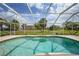 Inviting pool with a screened enclosure, surrounded by lush landscaping, creating a private oasis for relaxation at 26389 Villa Maria Dr, Punta Gorda, FL 33983