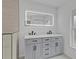 Modern bathroom featuring a double vanity with gray cabinets, black hardware, and illuminated mirror at 267 Camrose St, Port Charlotte, FL 33954
