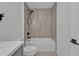 Modern bathroom with white tub and shower combination, tiled walls, and sleek black fixtures at 267 Camrose St, Port Charlotte, FL 33954