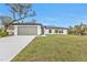 Charming single-story home with a well-manicured front yard, a two-car garage and a welcoming entrance at 267 Camrose St, Port Charlotte, FL 33954