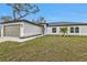 Charming single-story home with a lush green lawn, a two-car garage, and manicured landscaping at 267 Camrose St, Port Charlotte, FL 33954
