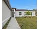 Inviting front entrance with lush landscaping leading up to a modern gray front door at 267 Camrose St, Port Charlotte, FL 33954