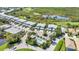 Aerial view of a neighborhood featuring lush greenery, a pool, a golf course, and a pond at 3393 Grand Vista Ct # 101, Port Charlotte, FL 33953