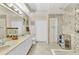 Bathroom featuring double sinks, ample counter space, a walk-in shower with designer tile work, and a linen closet at 3393 Grand Vista Ct # 101, Port Charlotte, FL 33953