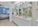 Bright bathroom features double sinks, white cabinets, decorative mirror and tiled shower at 3393 Grand Vista Ct # 101, Port Charlotte, FL 33953