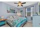 Comfortable bedroom with blue walls, ceiling fan, and coastal-themed decor and furnishings at 3393 Grand Vista Ct # 101, Port Charlotte, FL 33953