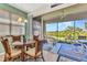 Cozy dining area featuring a glass table and wicker chairs with a screened-in patio and lush outdoor view at 3393 Grand Vista Ct # 101, Port Charlotte, FL 33953