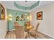 Bright dining room with a glass table, four chairs, decorative lighting, and a palm tree art piece at 3393 Grand Vista Ct # 101, Port Charlotte, FL 33953