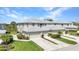 Exterior of a well-maintained townhome with a manicured lawn, landscaping, and parking spaces at 3393 Grand Vista Ct # 101, Port Charlotte, FL 33953
