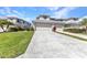Exterior shot of a townhome with an attached garage, manicured lawn, and driveway at 3393 Grand Vista Ct # 101, Port Charlotte, FL 33953