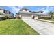 Exterior shot of a townhome with an attached garage, manicured lawn, and driveway at 3393 Grand Vista Ct # 101, Port Charlotte, FL 33953
