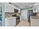 Modern kitchen with white cabinets, stainless steel appliances and convenient pantry at 3393 Grand Vista Ct # 101, Port Charlotte, FL 33953