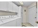 Bright laundry room with a washer, dryer, built-in cabinets, and a convenient tiled floor at 3393 Grand Vista Ct # 101, Port Charlotte, FL 33953
