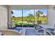 Screened patio with view of tropical vegetation, table and chairs at 3393 Grand Vista Ct # 101, Port Charlotte, FL 33953